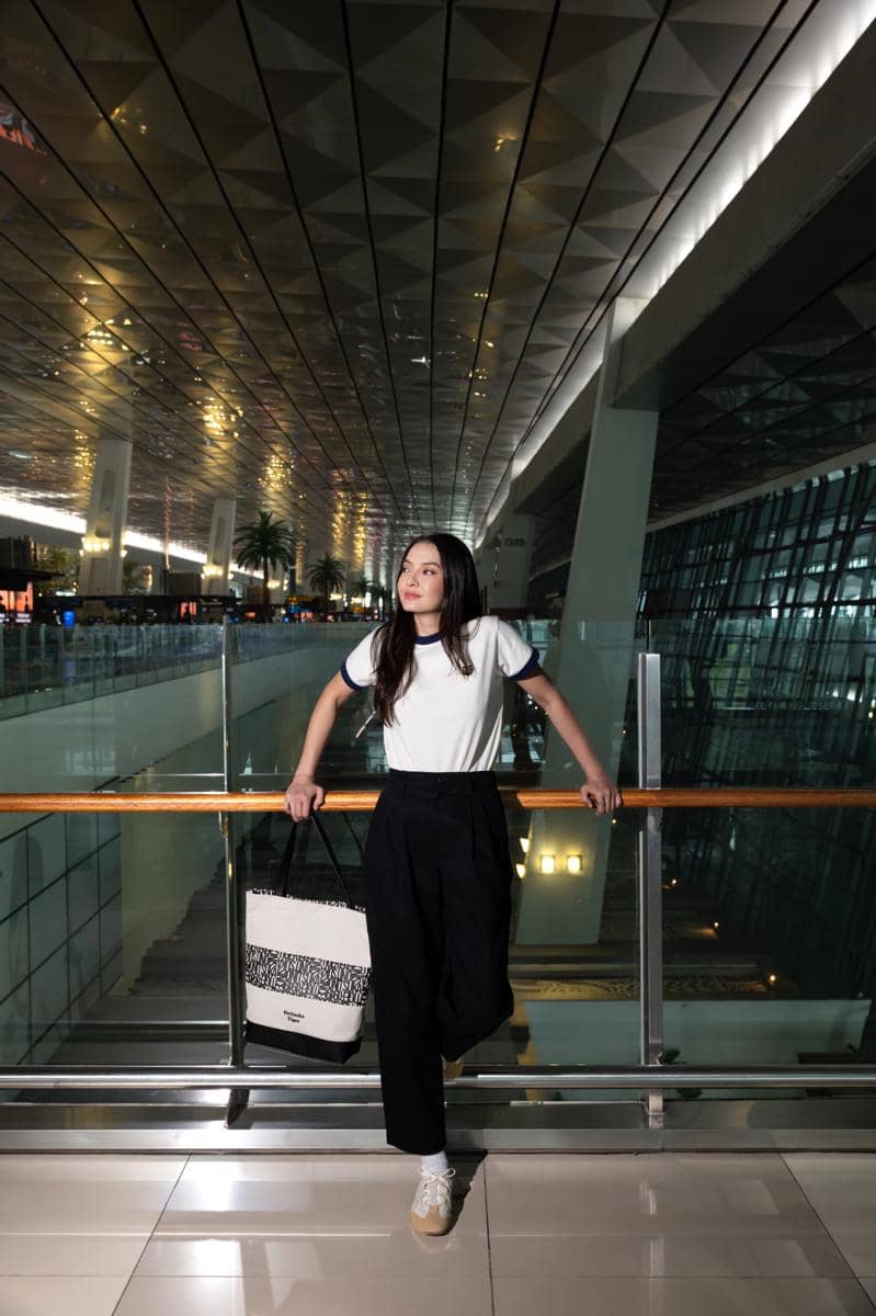 Raline Shah mengenakan ringer tee dan celana Onitsuka Tiger saat bersiap melakukan perjalanan menuju Milan.