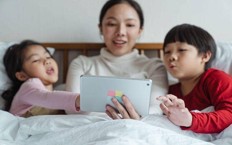 ilustrasi orang tua mendampingi anak saat menggunakan tablet