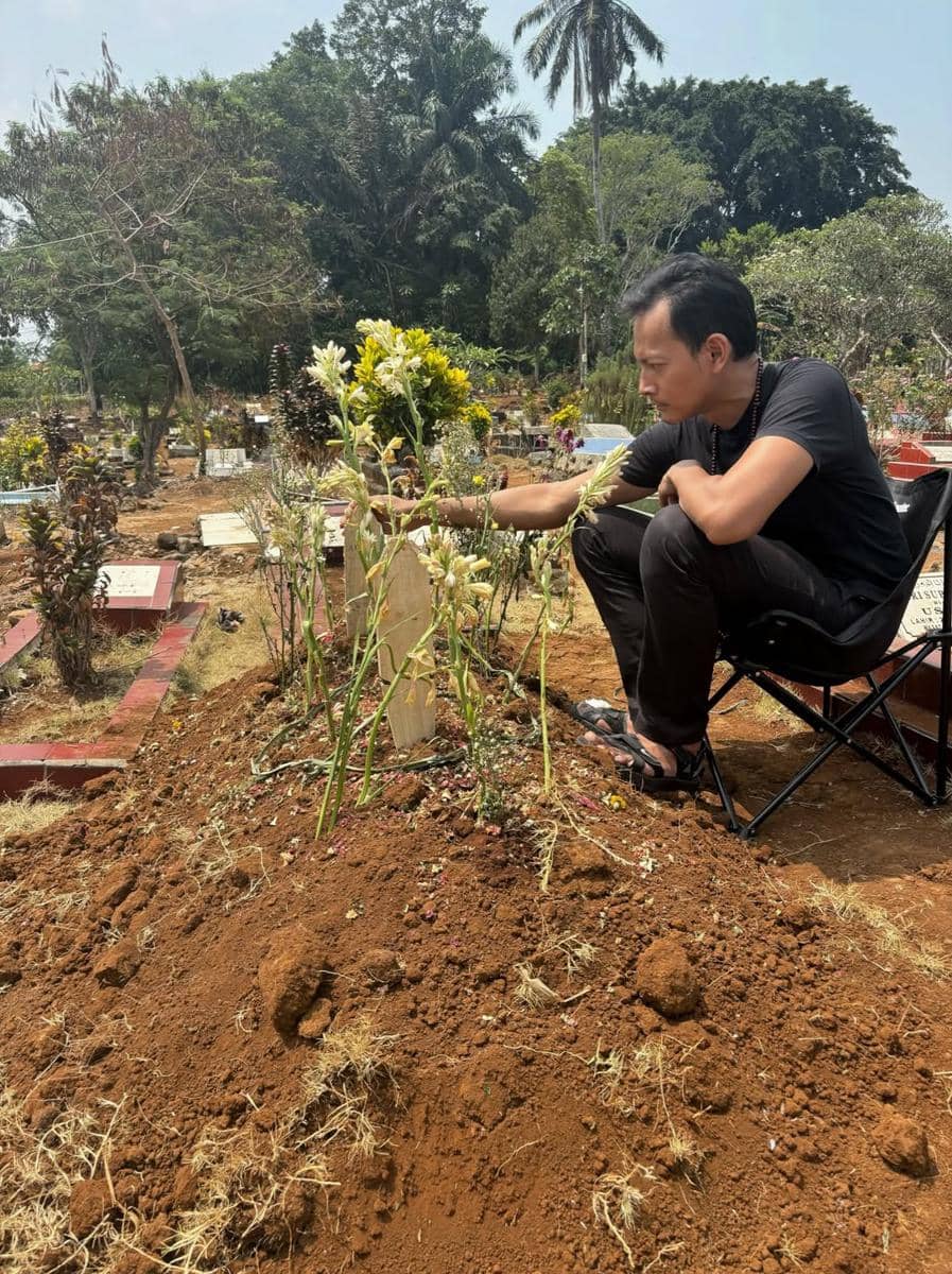 Personel band Garasi berziarah di makam Aries Budiman, berkumpul di area pemakaman sambil mendoakan almarhum.
