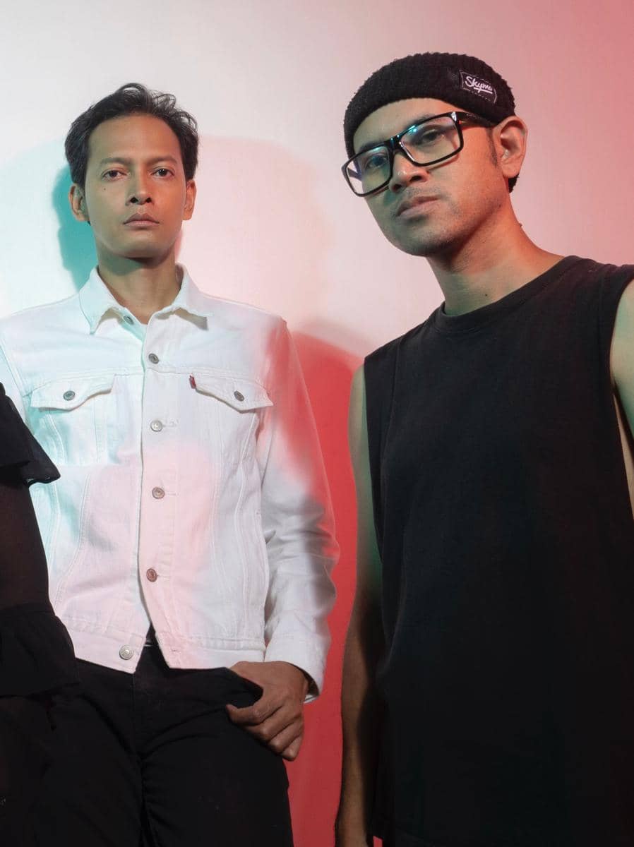 Personel band Garasi berziarah di makam Aries Budiman, berdiri di dekat pusara dengan nisan dan taburan bunga.