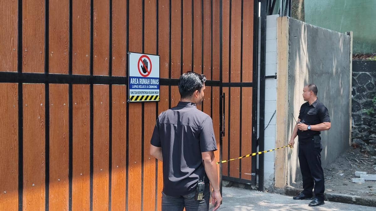 Gerbang masuk beratap menuju kawasan rumah dinas di Lapas Kelas IIA Cibinong, Bogor, dengan pepohonan di sekitarnya.