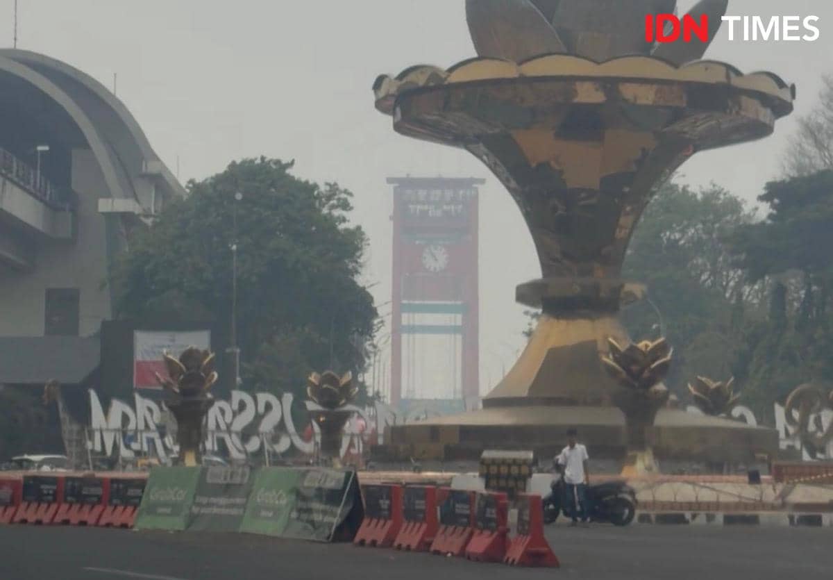 Kondisi kabut asap di kota Palembang yang tiba-tiba gelap ditutupi polusi kebakaran hutan dan lahan