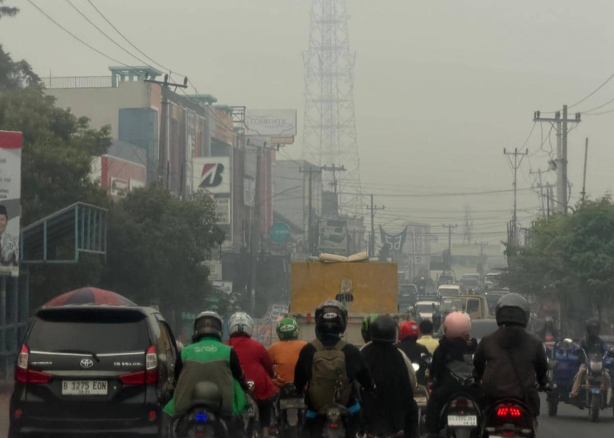 Kondisi kabut asap di kota Palembang yang tiba-tiba gelap ditutupi polusi kebakaran hutan dan lahan