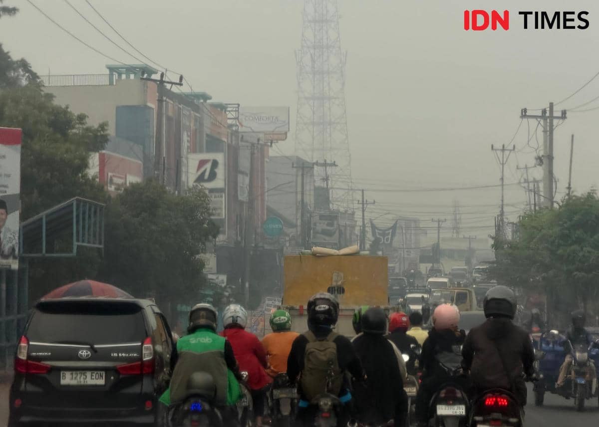 Kondisi kabut asap di kota Palembang yang tiba-tiba gelap ditutupi polusi kebakaran hutan dan lahan