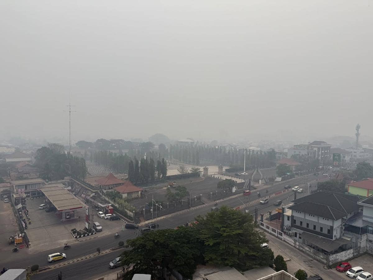 Kondisi kabut asap di kota Palembang yang tiba-tiba gelap ditutupi polusi kebakaran hutan dan lahan