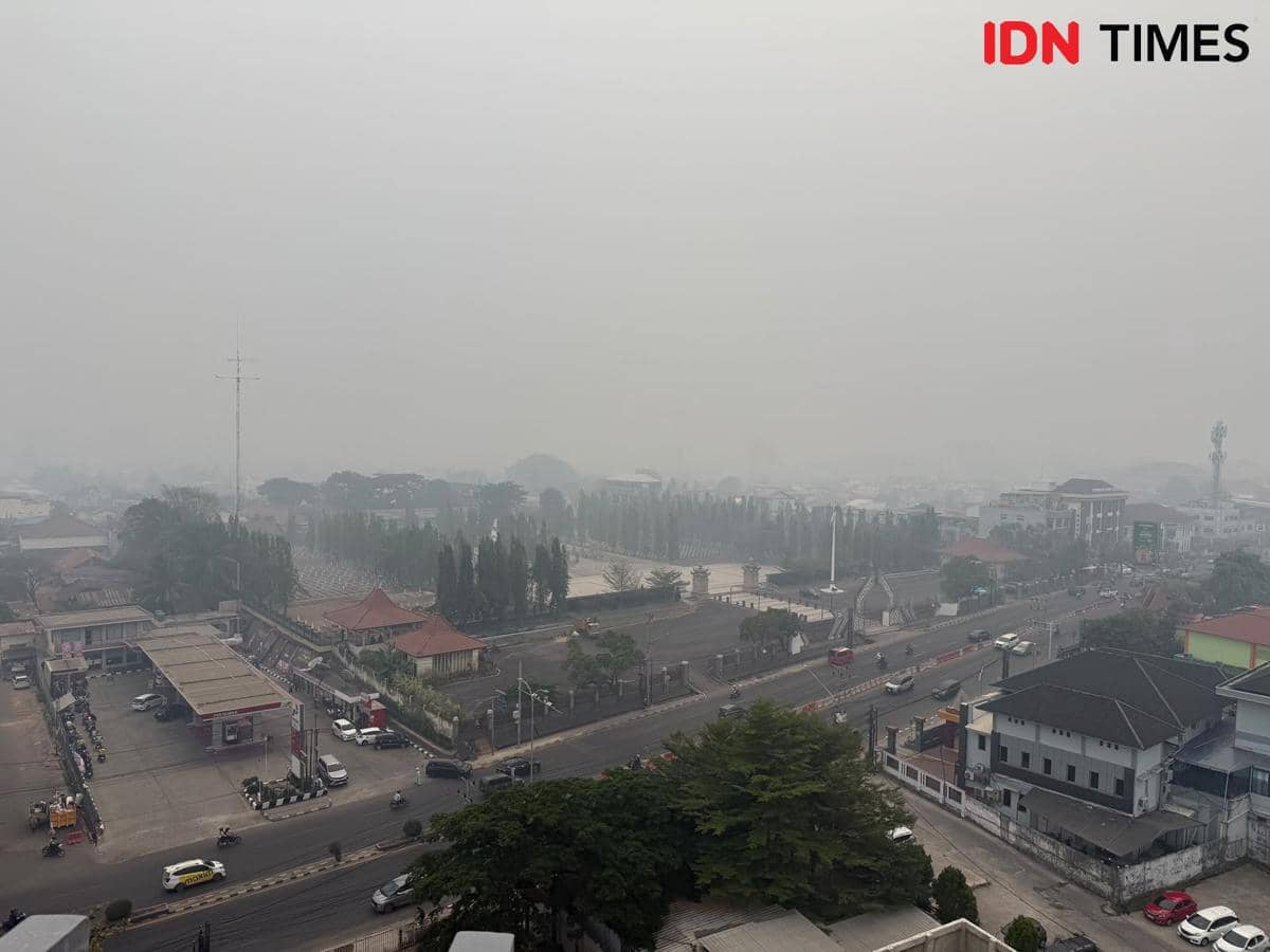 Kondisi kabut asap di kota Palembang yang tiba-tiba gelap ditutupi polusi kebakaran hutan dan lahan