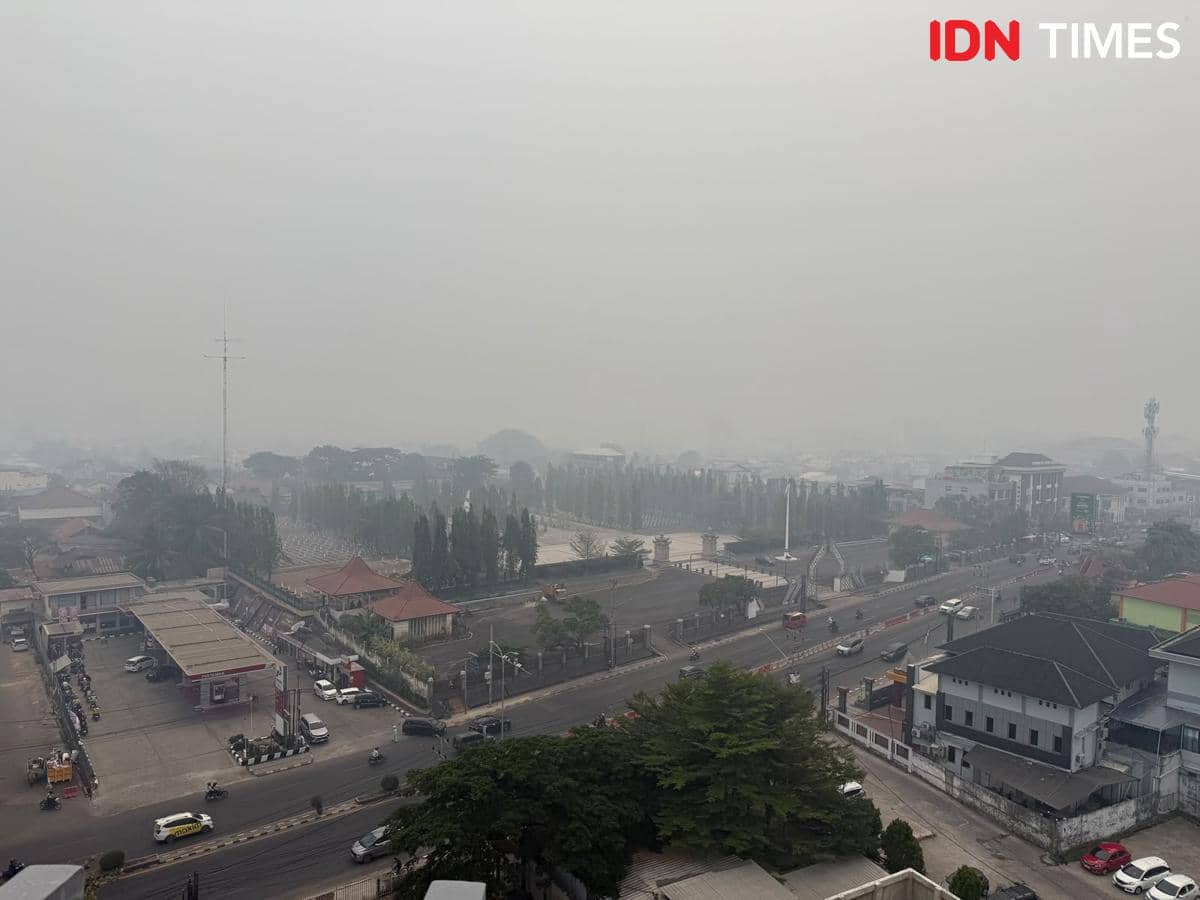Kondisi kabut asap di kota Palembang yang tiba-tiba gelap ditutupi polusi kebakaran hutan dan lahan