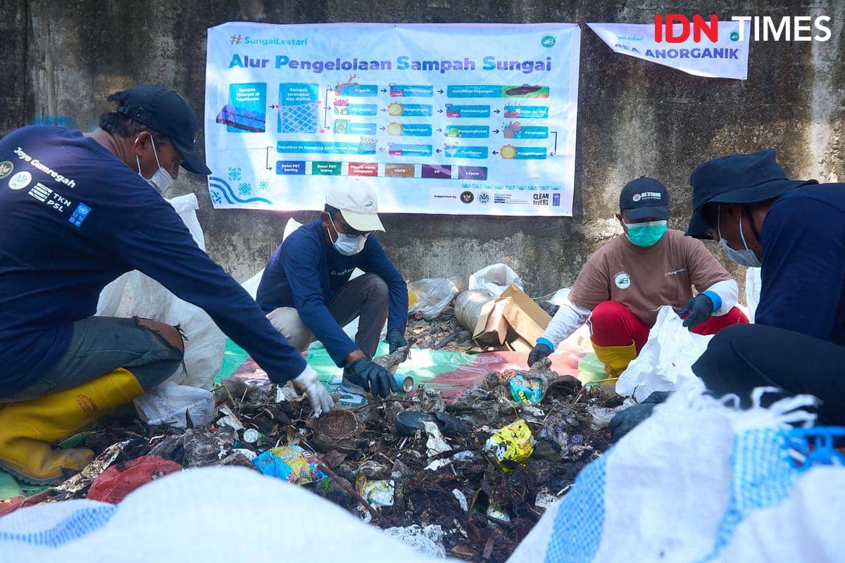 Sejumlah anggota Kelompok Pengelola Sampah Joyo Gumregah memilah sampah yang terjaring trash boom saat pelaksanaan Program Sungai Lestari di