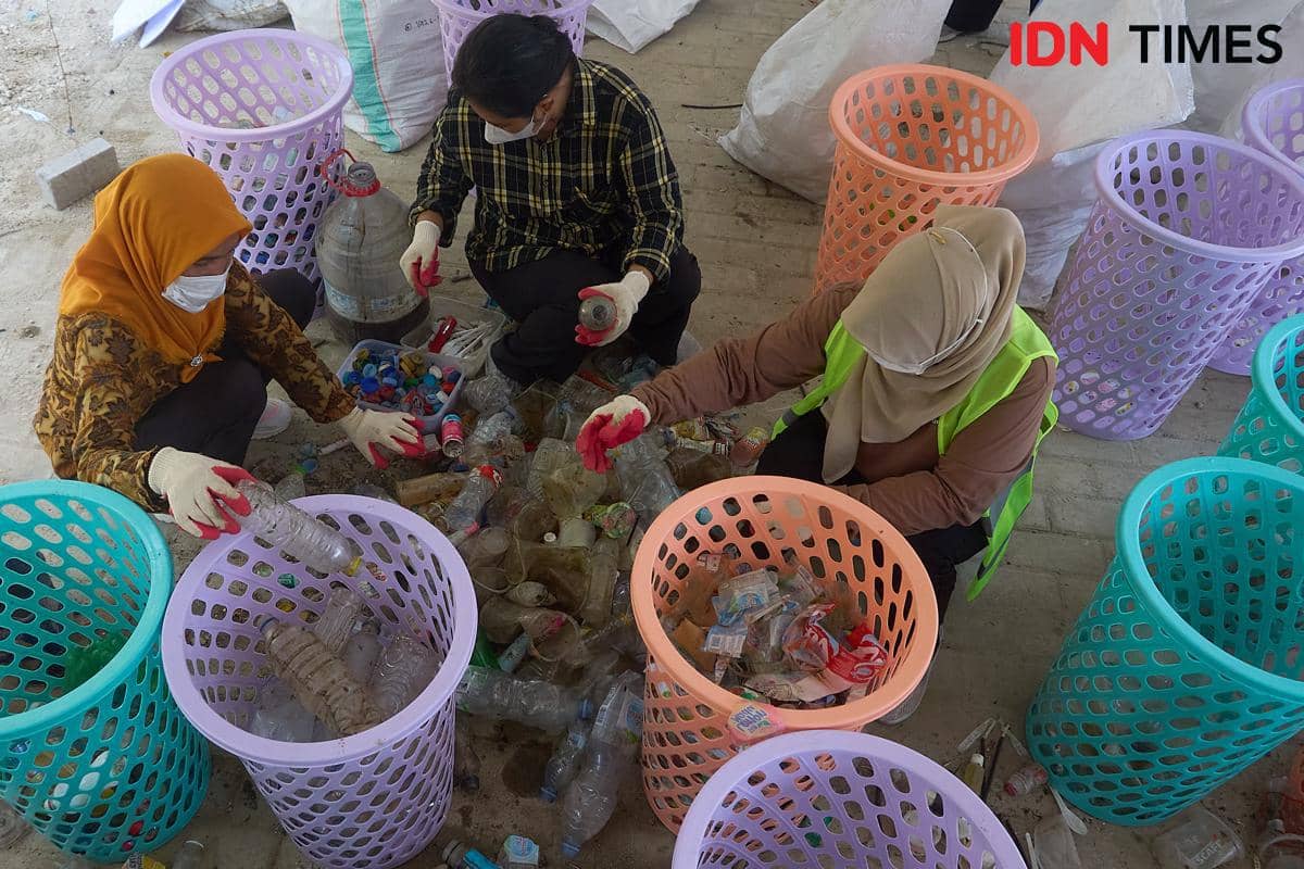 Sejumlah anggota Kelompok Pengelola Sampah Joyo Gumregah memilah sampah yang terjaring trash boom saat pelaksanaan Program Sungai Lestari di