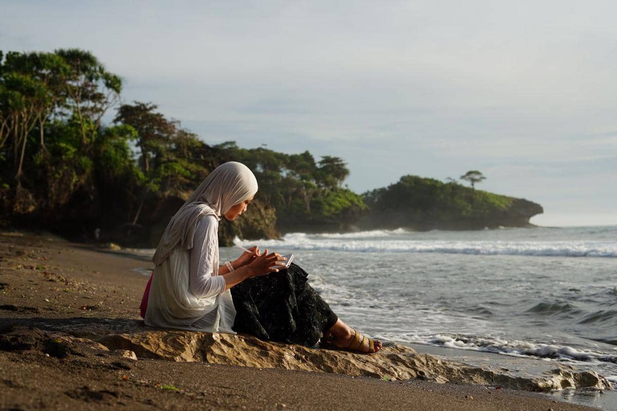 duduk di tepi pantai