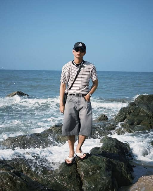 Vo Khanh Hung mengenakan OOTD bergaya kasual saat berada di pantai dalam unggahan Instagram pribadinya.