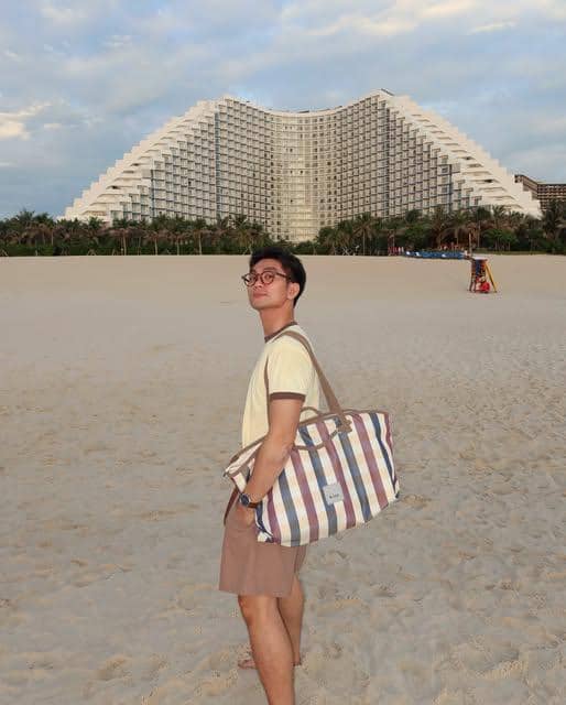 Vo Khanh Hung mengenakan OOTD kasual untuk suasana pantai dengan gaya santai dalam unggahan Instagram.