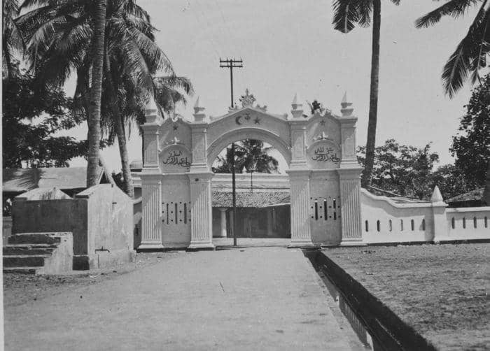 Tampak depan Masjid Luar Batang di Batavia pada 1920-an, dengan bangunan beratap genteng dan pepohonan di sekitarnya.