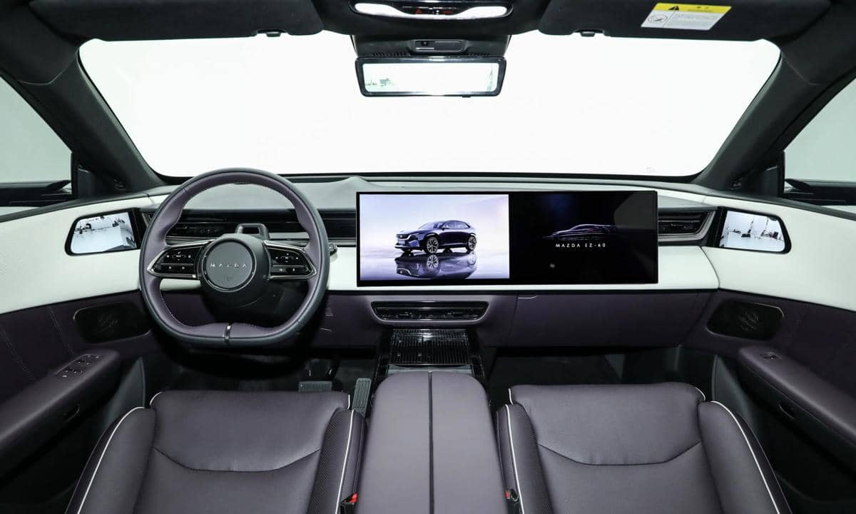 Interior Mazda CX-6e dengan dasbor modern, layar digital lebar, setir multifungsi, dan konsol tengah minimalis.