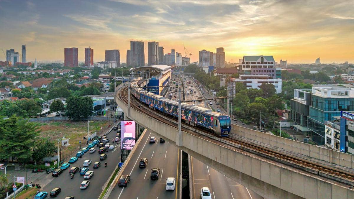 ilustrasi pemandangan udara sistem kereta elevasi Jakarta saat matahari terbenam dengan cakrawala kota