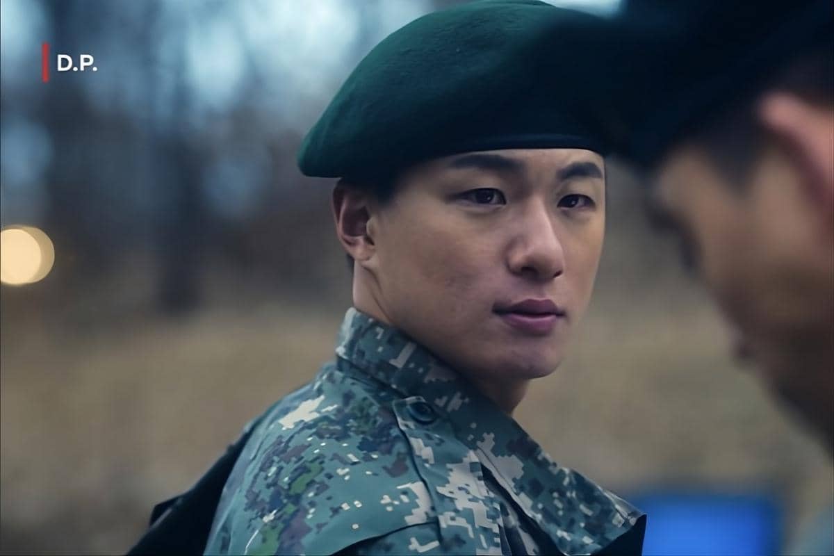 Potongan adegan aktor Shin Seung Ho mengenakan seragam militer dan baret hijau dalam serial D.P. di Netflix.