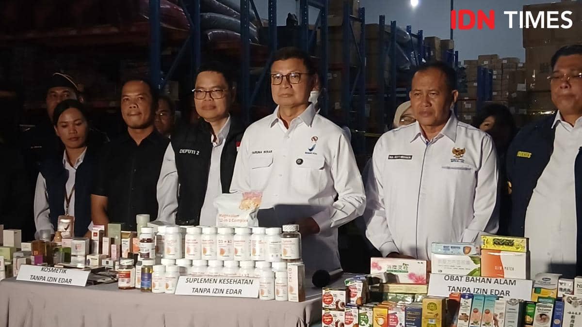 Petugas BPOM memeriksa tumpukan produk obat dan kosmetik ilegal saat penggerebekan gudang di Tangerang.
