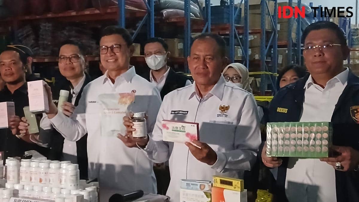 Petugas BPOM memeriksa tumpukan produk obat dan kosmetik ilegal saat penggerebekan gudang di Tangerang.