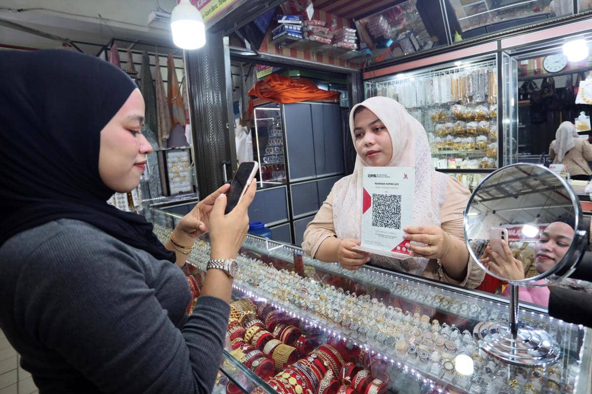 Ilustrasi konsumen memindai QRIS untuk melakukan pembayaran melalui aplikasi pembayaran digital di salah satu toko perhiasan. (ANTARAFOTO/Ak
