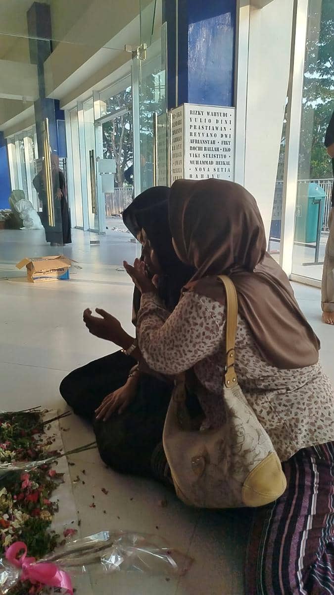 Sejumlah keluarga korban Tragedi Kanjuruhan memanjatkan doa dengan khidmat di depan Gate 13 Stadion Kanjuruhan.