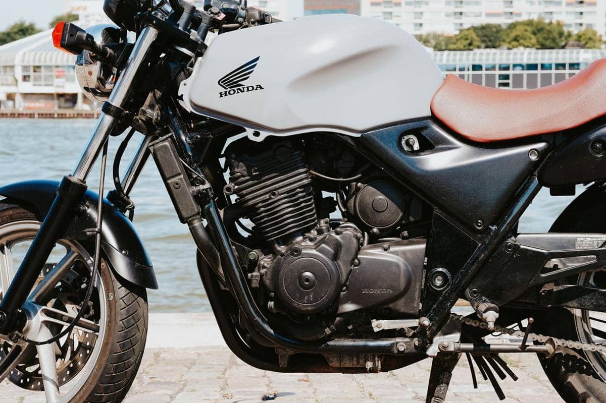 Ilustrasi mesin motor dengan komponen logam, kabel, dan bagian mekanis yang tampak dekat secara detail.
