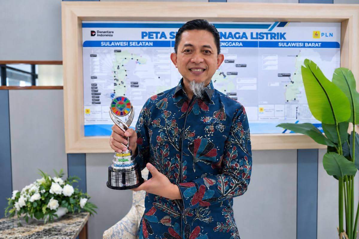 General Manager PLN UID Sulselrabar, Edyansyah, menunjukkan trofi Silver CSR dan PDB Awards 2026 yang diraih melalui program Kampung Energi