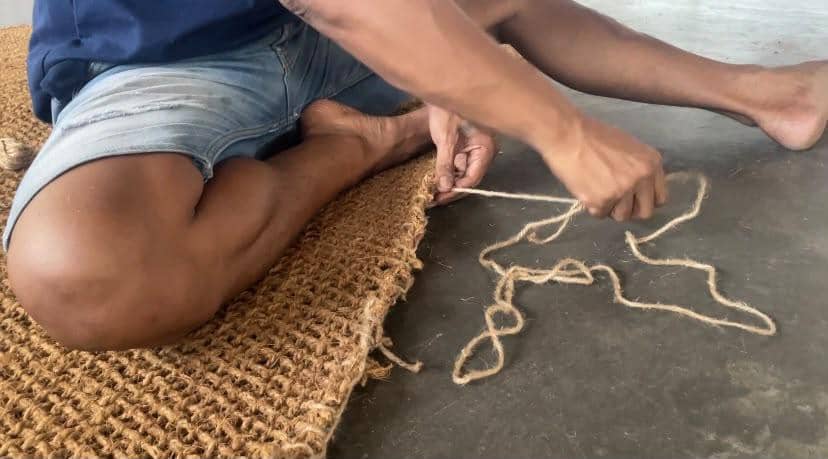 Bayu menganyam sabut kelapa menjadi produk kerajinan layak ekspor di area kerja sederhana miliknya.
