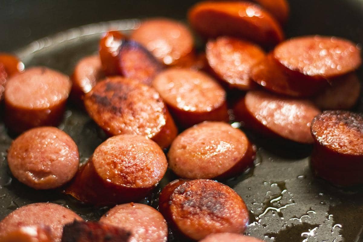 Ilustrasi hidangan Italian sausage orzo, pasta berbentuk beras dengan sosis Italia, untuk inspirasi memasak di rumah.