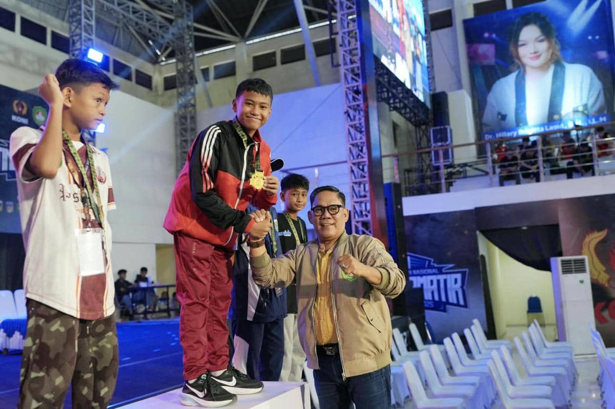 Sekretaris Pengprov PERTINA Sulsel Sri Syahril usai mengalungkan medali juara kepada petinju muda Sulsel Izack Timothy Masihor pada Kejurnas