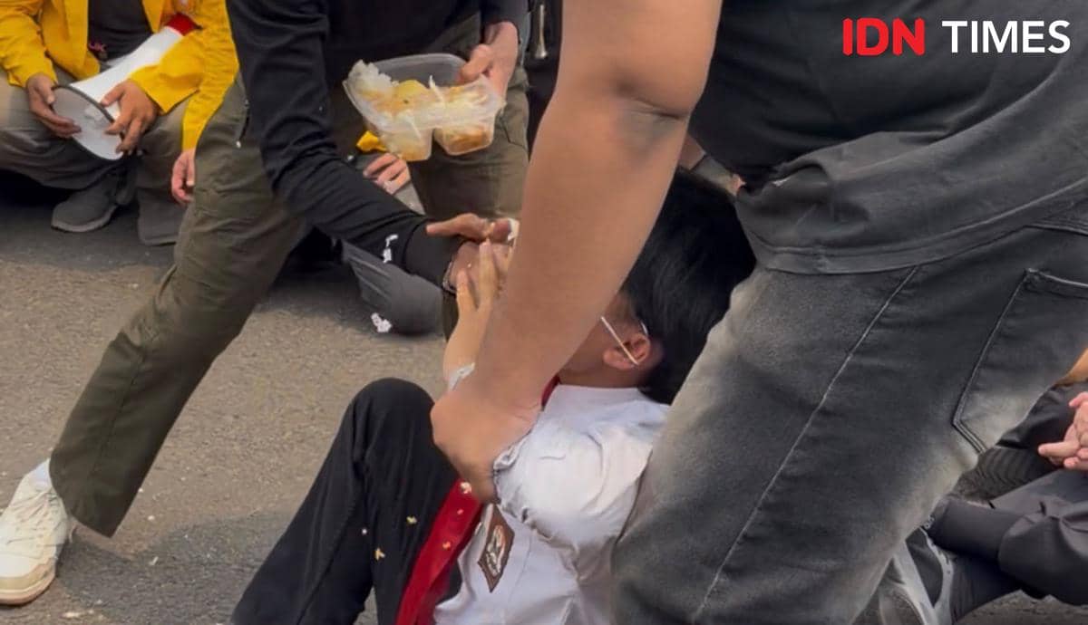 Peserta aksi teatrikal menanam sawit dan menyantap MBG di tengah kabut asap yang masih menyelimuti area aksi.