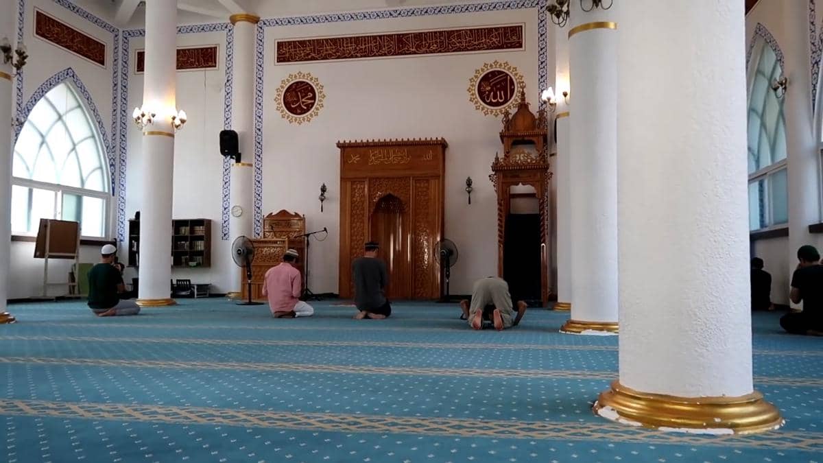 Interior aula salat Masjid Al-Fatah Busan, dengan mihrab dan mimbar berada di bagian depan ruang ibadah.