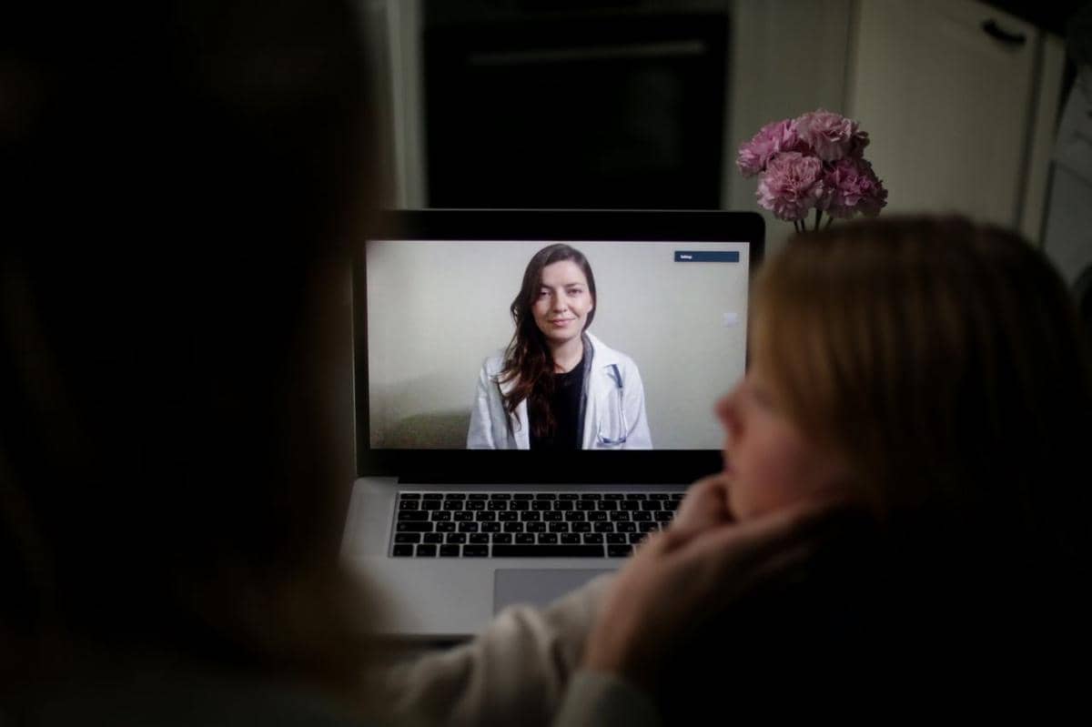 Ilustrasi telemedicine berupa konsultasi kesehatan jarak jauh antara pasien dan tenaga medis melalui perangkat digital.