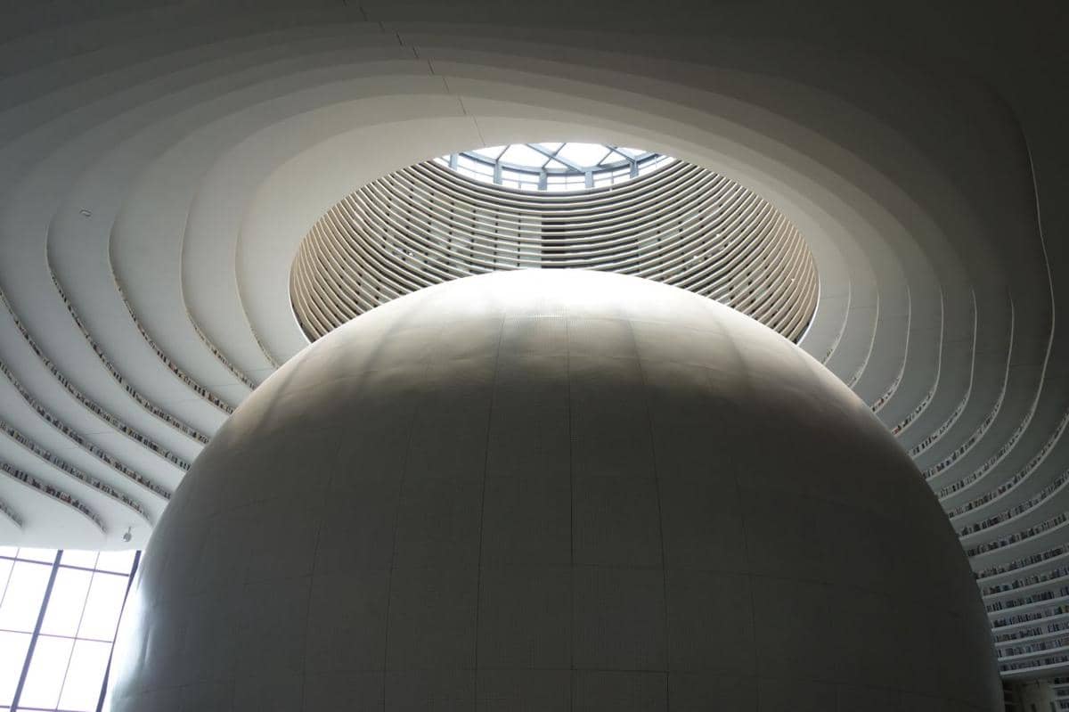 Auditorium berbentuk bola besar dan bercahaya, yang dijuluki "The Eye," di Tianjin Binhai Library.