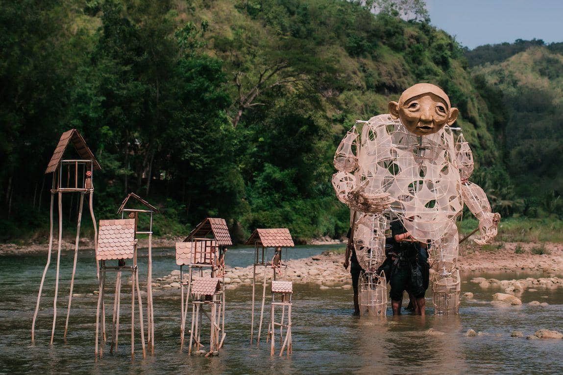 Dokumentasi Papermoon Puppet Theatre dalam sesi pemotretan di tepi sungai dengan suasana artistik yang khas.