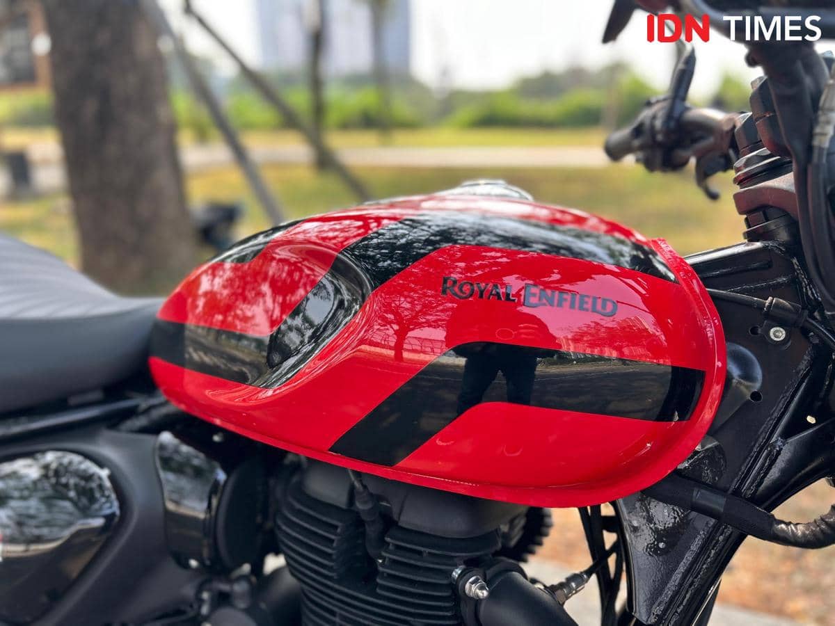 Tangki bahan bakar model teardrop berwarna gelap pada sepeda motor klasik, dengan bentuk membulat dan garis desain sederhana.