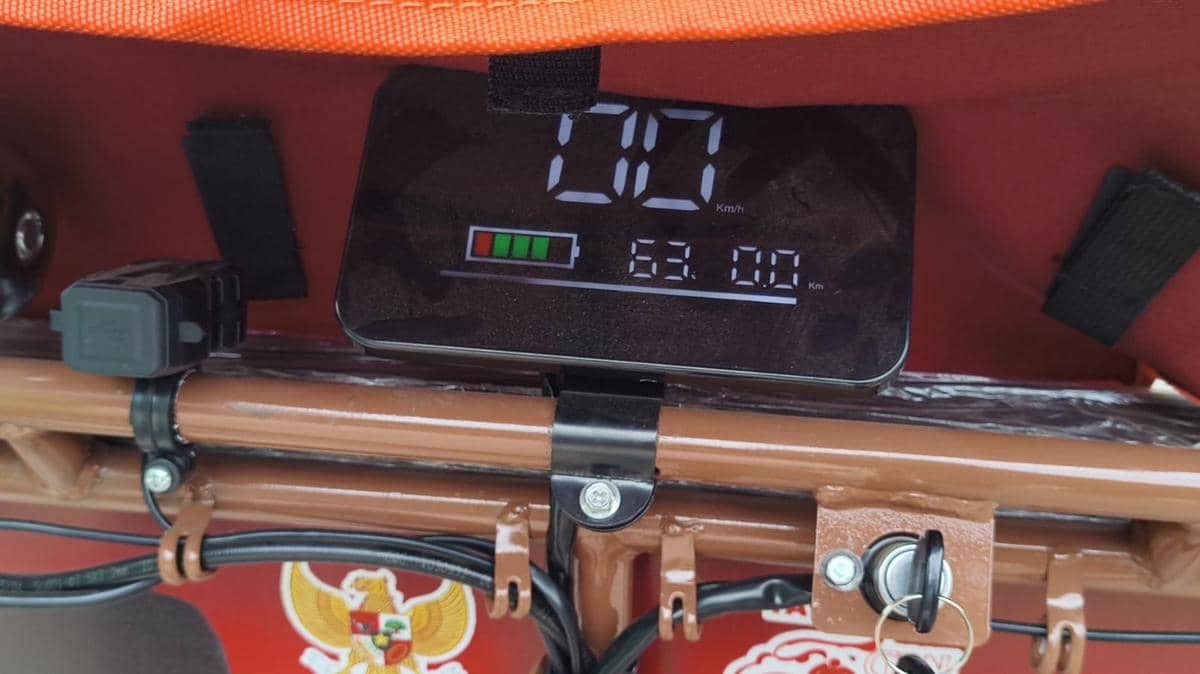 Panel indikator digital pada becak listrik yang menampilkan informasi operasional kendaraan di bagian kemudi.