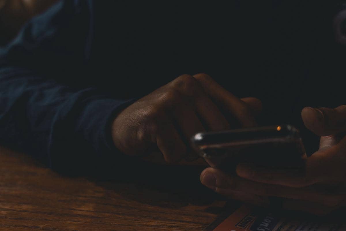 Orang sedang fokus menggunakan smartphone