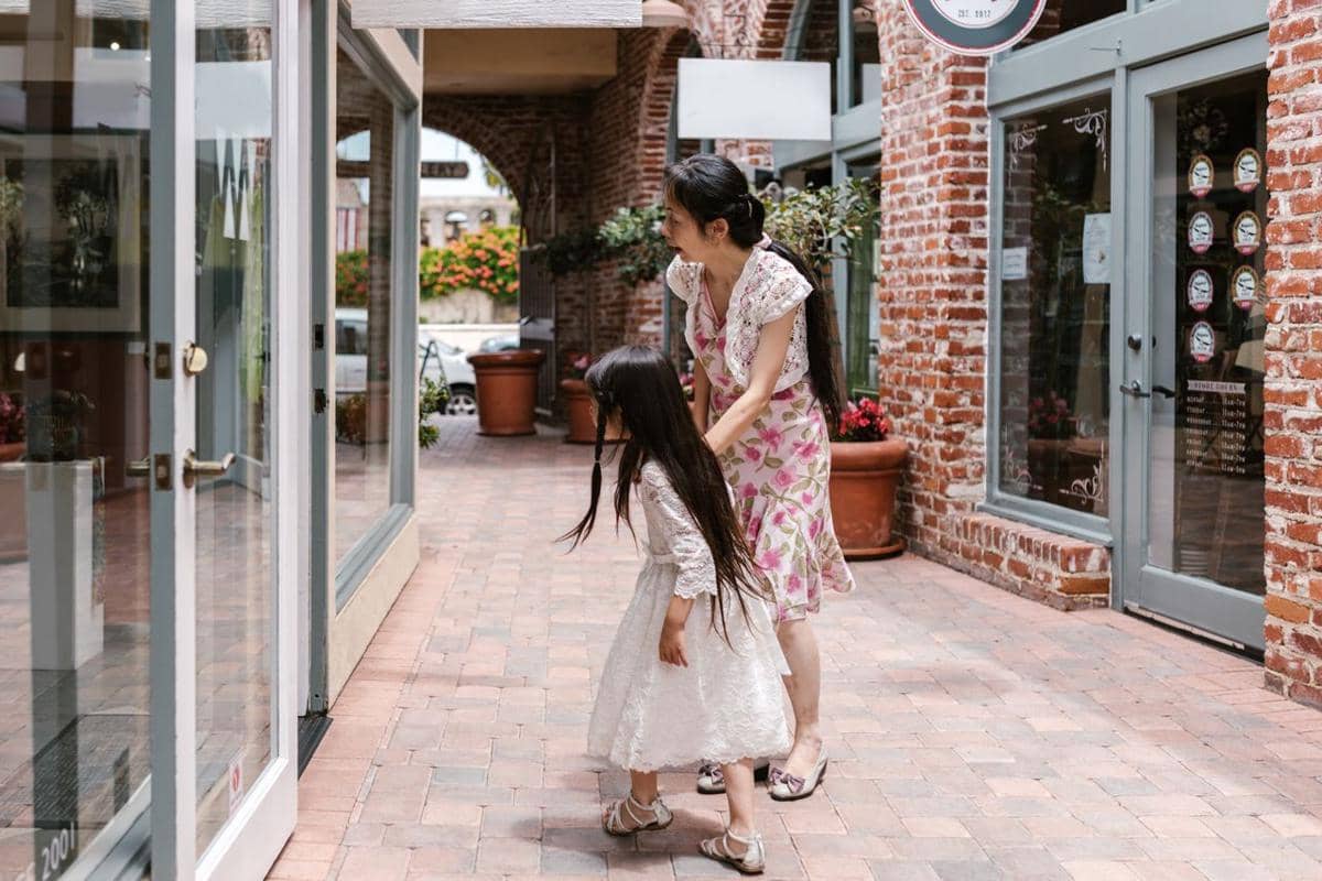 Seorang ibu berjalan-jalan bersama anaknya yang mengidap cerebral palsy di luar ruangan sebagai ilustrasi dukungan keluarga.