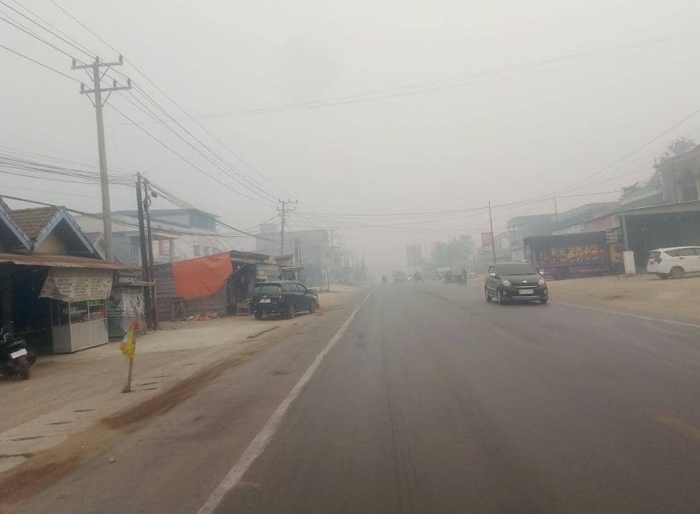 Suasana jalan raya yang dipenuhi kabut asap pekat dengan jarak pandang terbatas di wilayah Bayung Lencir Musi Banyuasin.