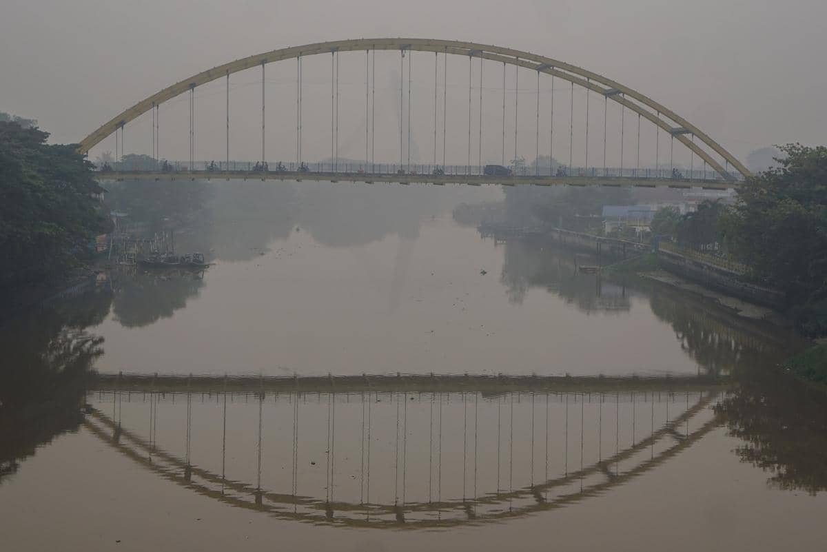 Kendaraan melintas di Jembatan Siak III, Pekanbaru, saat kabut asap tebal membatasi jarak pandang hingga kurang dari satu kilometer.