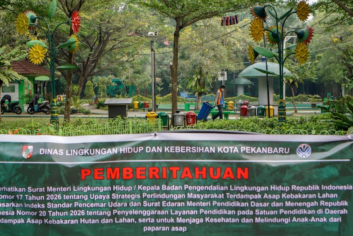 Petugas DLHK Pekanbaru membersihkan kawasan RTH Putri Kaca Mayang yang ditutup sementara akibat asap karhutla.