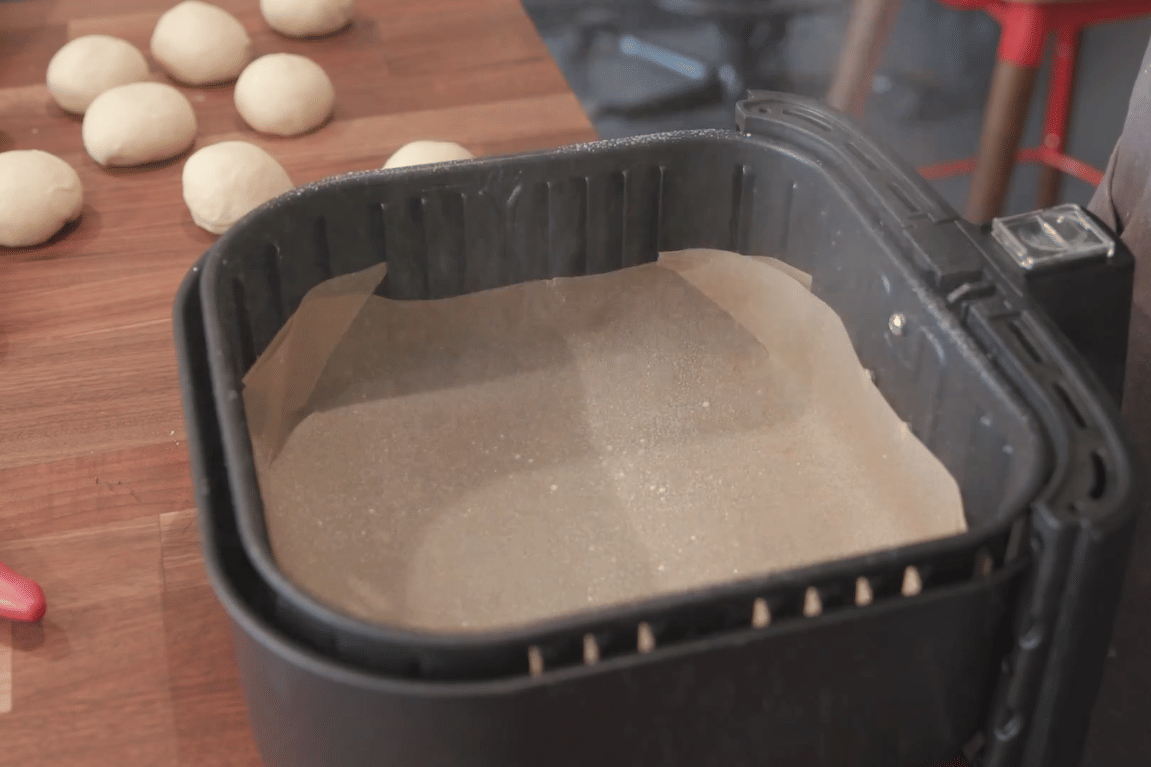 ilustrasi melapisi alas air fryer dengan kertas roti