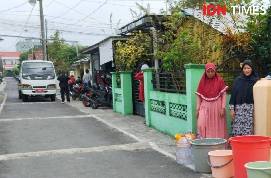 Petugas PDAM Banyumas menyalurkan air bersih kepada warga Purwokerto Selatan melalui layanan droping air.