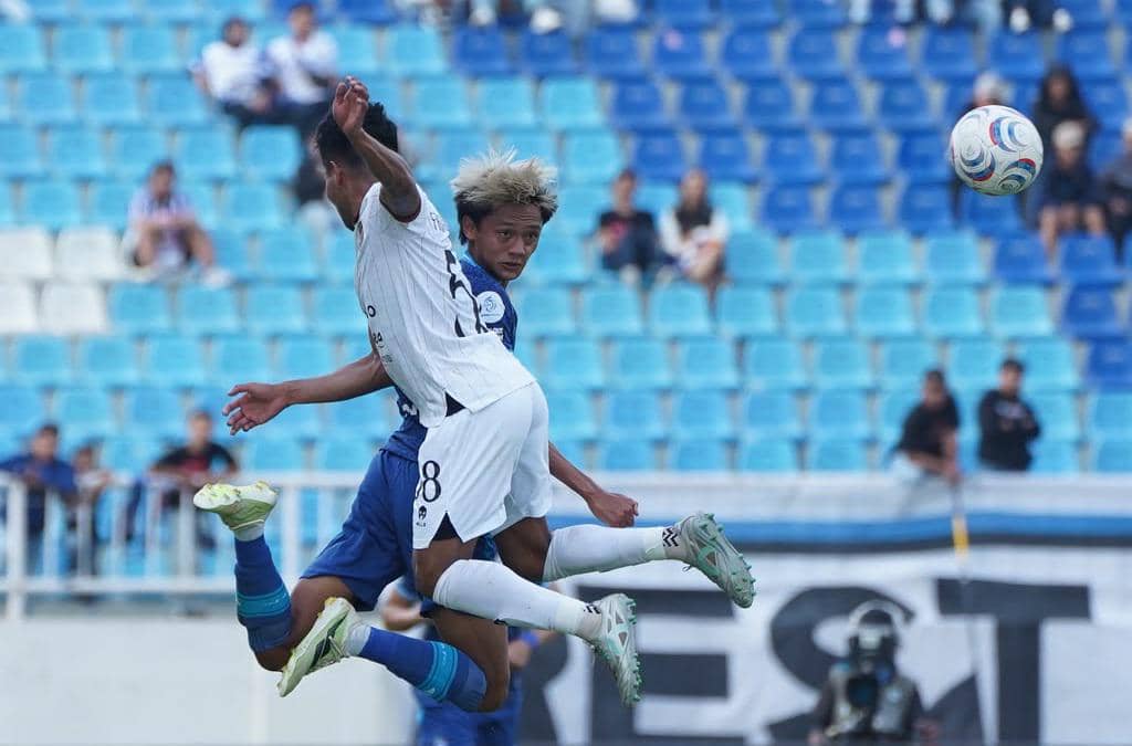 Pertandingan Arema FC melawan Bhayangkara FC berlangsung di Stadion Kanjuruhan dengan para pemain di lapangan.
