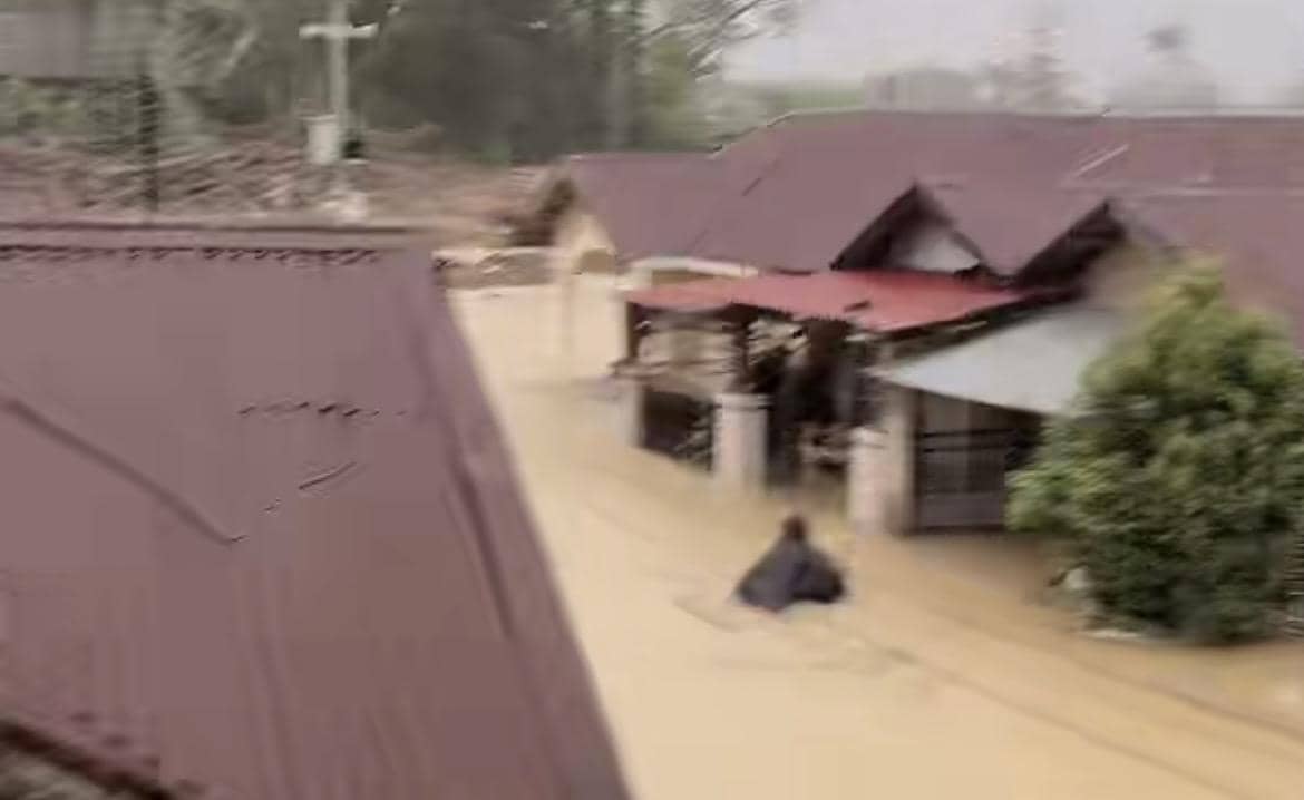 Warga melewati banjir di daerah Tabing Banda Gadang (Foto: Istimewa)