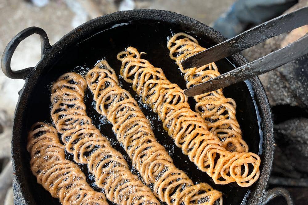 ilustrasi menggoreng kue akar kelapa