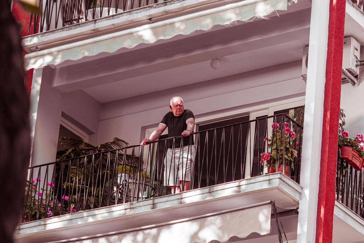 Pria tua di balkon rumah.