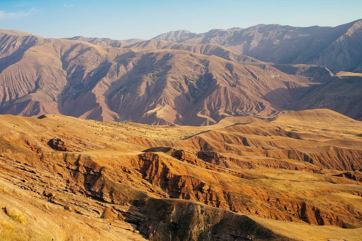 Hamparan pegunungan dan lembah hijau terlihat dari Kastel Alamut di Iran, di bawah langit yang cerah.