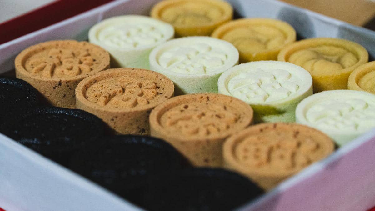 Bola-bola kue beras Korea gyeongdan berwarna-warni tersaji rapi di atas piring putih sebagai hidangan manis.
