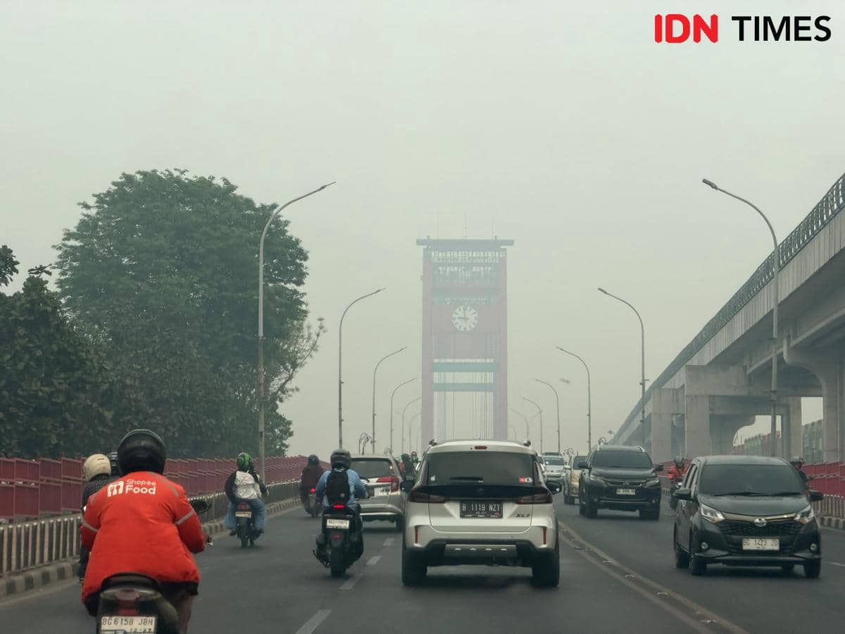 Kondisi kabut asap yang melanda kota Palembang menutup ikon kota Jembatan Ampera 